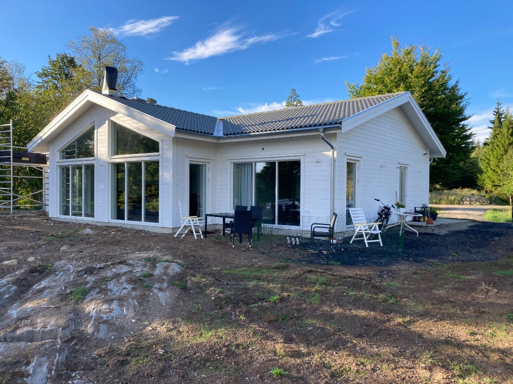 Färdig vit villa i Hjortsjö med stora fönster mot trädgården